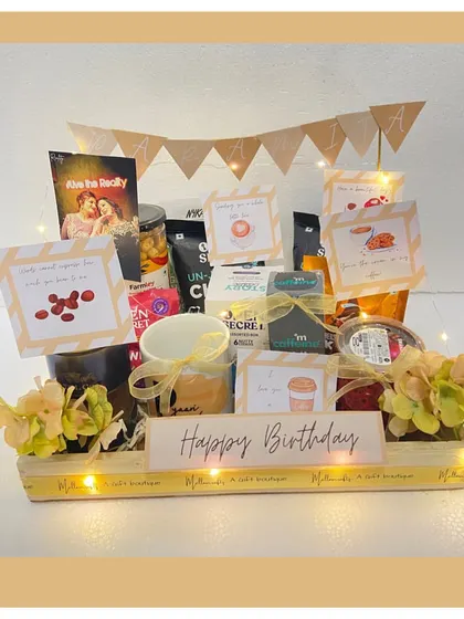 For the coffee aficionado, this birthday hamper is a dream. It's packed with different types of coffee, cookies, and a personalized 'Happy Birthday' banner, all illuminated with fairy lights.