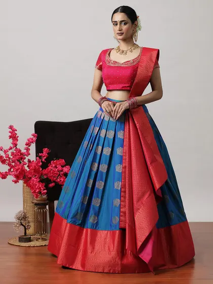 A striking blue and red half-saree lehenga, featuring silver buti work on the skirt and a rich red Banarasi border.