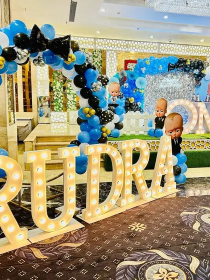 The main hall decoration for Rudra's Boss Baby party, showing the stage and large marquee letters.