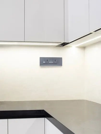 The matte black faucet and sink are a sophisticated touch against the white and black palette. This close-up also shows the subtle texture of the backsplash, which adds another layer of detail to the space.