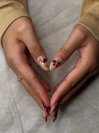 A heart shape made with the hands shows off the beautiful, detailed nail art from every angle.