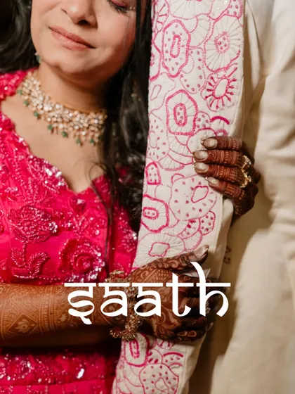 The Hindi word "Saath" (Together) overlaid on a close-up of the couple's hands. This artistic shot beautifully symbolizes their bond and the promise of togetherness.