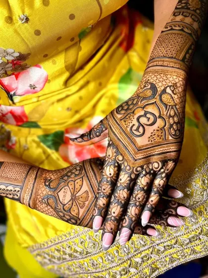 A close-up of a back-hand design featuring a peacock and the Om symbol. The combination of traditional motifs and delicate floral patterns is simply beautiful.