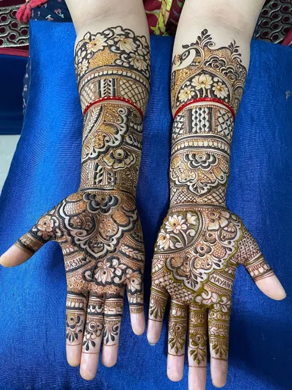 A beautiful full-hand design with intricate floral and paisley patterns. The names of the couple, Arshad and Mayank, are hidden in the design.