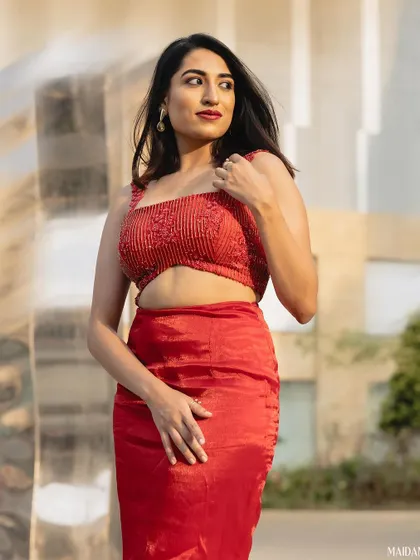 This red co-ord set features a hand-beaded crop top and a sleek satin skirt, designed for a modern, edgy look.