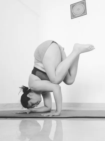 A close-up of the tucked Pincha pose, showing the engagement in the shoulders and core.