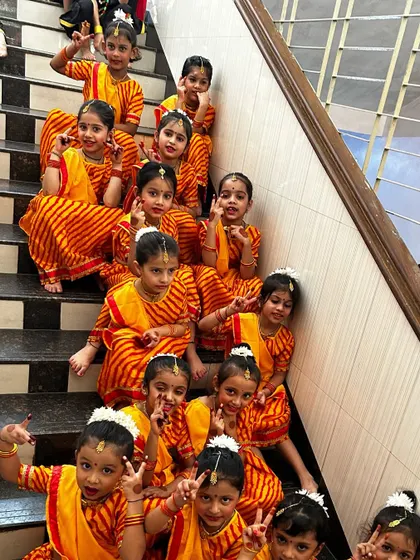 Our adorable young dancers in traditional attire, sitting on the stairs backstage.