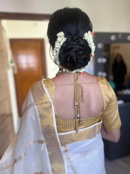A simple and elegant messy bun decorated with fresh jasmine. This is a classic choice for a Kerala bride or for any bride wanting a sophisticated look.