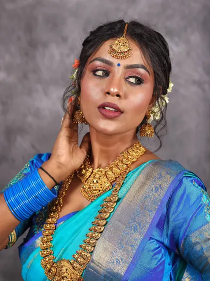A classic portrait pose in a blue saree, looking away from the camera for a candid and thoughtful feel.