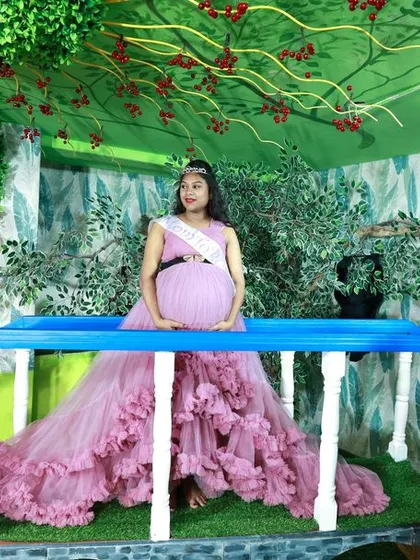 A beautiful solo maternity shot on our indoor bridge set, with the long trail of the lavender gown spread out elegantly.