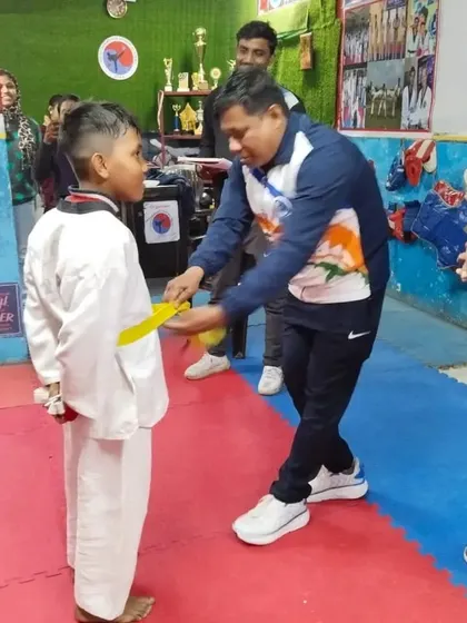 Awarding a new yellow belt to a deserving student. His hard work in class is showing.