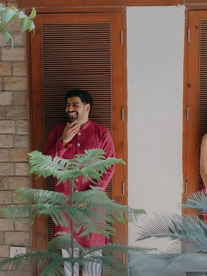 A candid moment of shared laughter on a balcony. We love capturing these unposed interactions that show the genuine friendship behind the romance.