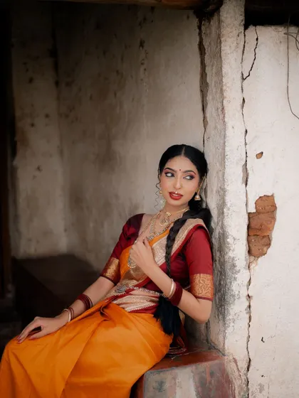 A quiet moment of reflection. This pose highlights the bride's profile and the intricate details of her braided hair and traditional jewelry.