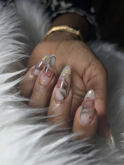 This is an example of soft, elegant nail art perfect for a minimalist bride. The delicate, hand-painted flowers on long, clear stiletto extensions with a hint of gold foil add a touch of romance without being overpowering.