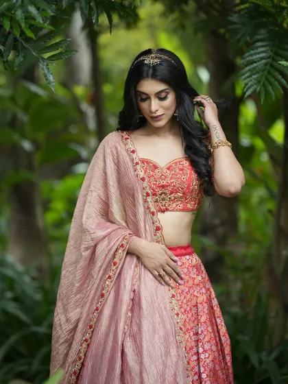 A final look at this stunning coral-red half saree, a testament to the blend of traditional fabrics and modern bridal design.