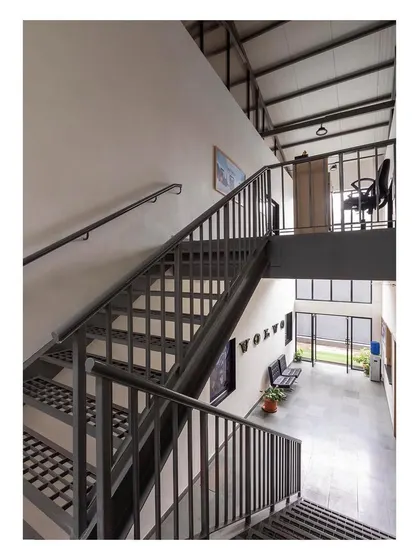 The central staircase, crafted from metal, serves as a strong architectural element connecting the ground floor warehouse functions with the first-floor office spaces.