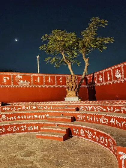 A night view of the Warli art we painted on the amphitheater at Epsilon, with the moon in the sky. The traditional white figures stand out against the rich red walls.