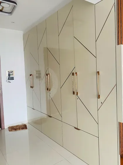 A high-gloss wardrobe with a bold geometric line pattern. The long, elegant handles add to the sophisticated design.