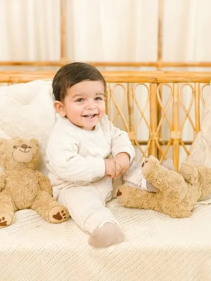 The purest joy captured in a sitter session. The baby's giggling expression and playful pose make this an incredibly cheerful and charming photograph.