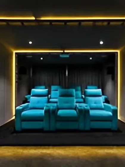 A dedicated home theater room with plush recliner seats and atmospheric lighting, designed for the ultimate cinematic experience.