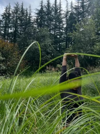 Stretching in a field of tall grass. My retreats are about finding moments to go easy, be filled with light, and shine, just as nature does.