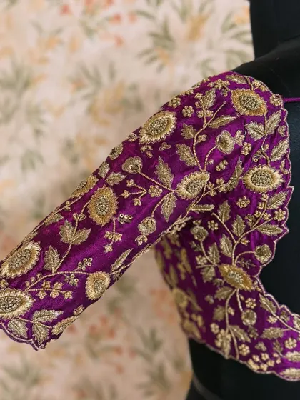 A close-up of a sleeve from a purple raw silk blouse. The zardozi work creates beautiful floral motifs with a wonderful 3D effect.