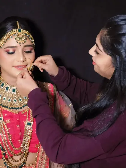 Behind the scenes of a bridal shoot, showing the final touches being applied to the model.