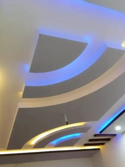 This design uses yellow and blue lights to trace the elegant curves of the ceiling. The dark wood-finished beams add a nice contrast.