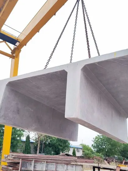 A precast concrete double-T slab being lifted by a crane. Using precast elements allows for faster construction and high-quality factory finishes.
