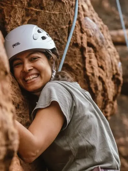 A climber hugs the rock, smiling, perfectly capturing the joy and connection we find in this sport. It's about embracing the challenge with a positive spirit.
