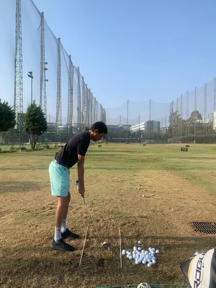 A young student practicing his iron shots at the KGA driving range. We use alignment sticks to ensure proper setup and aim, building good habits from the start.