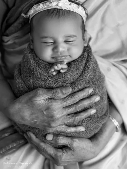 A truly special moment capturing four generations of love. This black and white portrait of a great-grandmother holding her newborn great-grandchild is a powerful and priceless family heirloom.