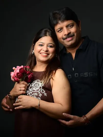 Another pose from the same anniversary session, this time with a bouquet of flowers, showcasing a soft and romantic feel.