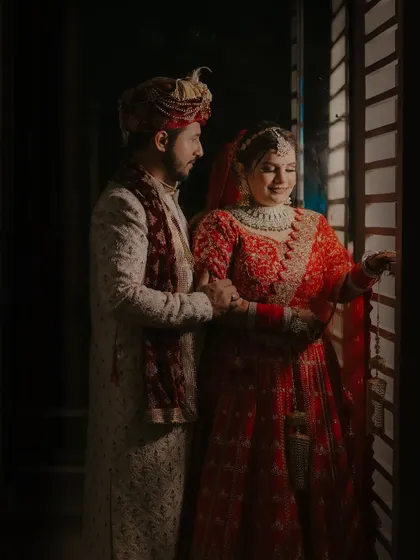 An intimate portrait of the couple by a window, using natural light to create a soft and romantic mood.