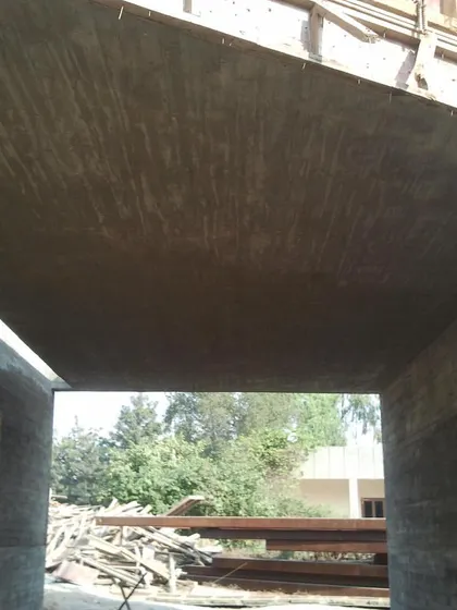 A view from underneath a concrete bridge element during the construction of the Rhizome House. The surface shows the texture from the plank shuttering.