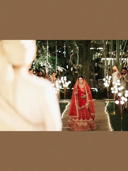 The bride's dramatic entrance, walking down an aisle of lights towards her waiting groom.
