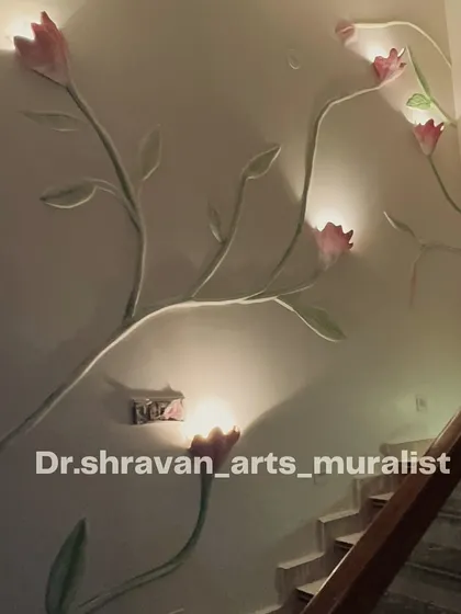 A beautiful relief mural of flowering vines climbing up a staircase wall. We integrated lights inside the sculpted blossoms, turning them into unique, artistic wall sconces.