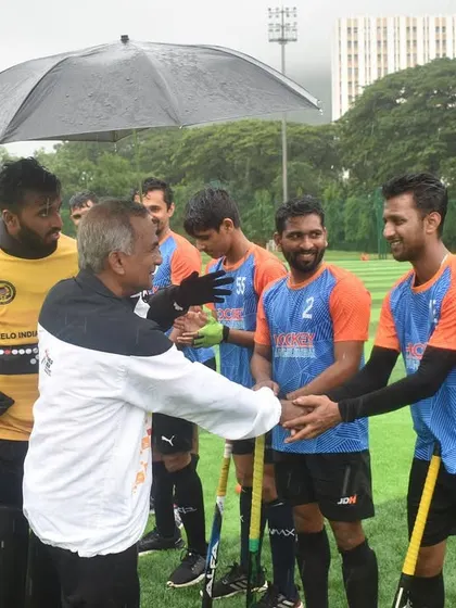 A gesture of respect as players shake hands with an official after the game. We value fair play and appreciate the hard work of everyone involved in the tournament.