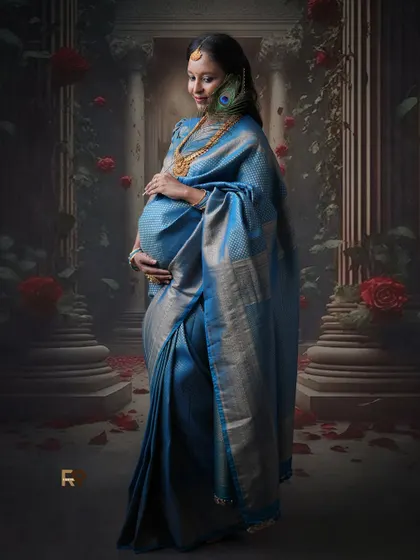 A touch of mystique. The peacock feather in her hair adds a symbolic element to this beautiful portrait of the mom-to-be in her blue silk saree.