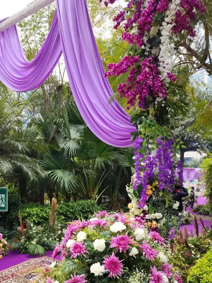 A close-up of a floral pillar and draped fabric along a walkway, showcasing the lush and detailed arrangements we create.