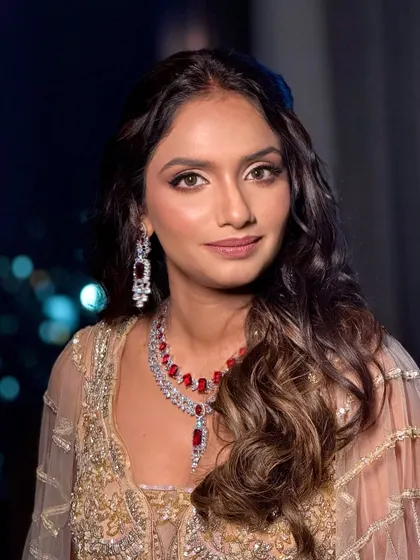 A direct portrait of the client, looking confident and stunning with her bold jewelry and soft glam makeup.