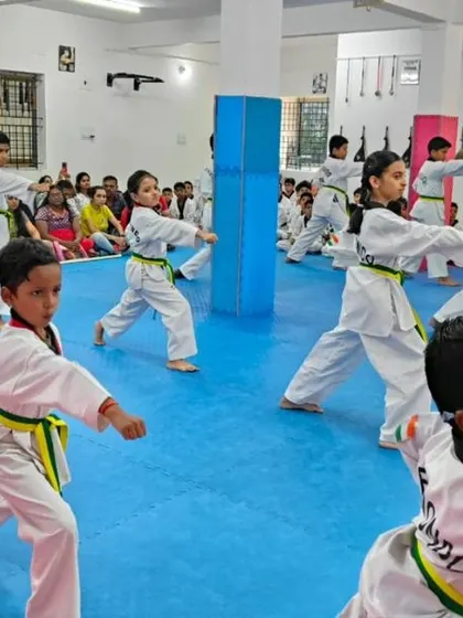 A class of green belts practicing their punches in unison.