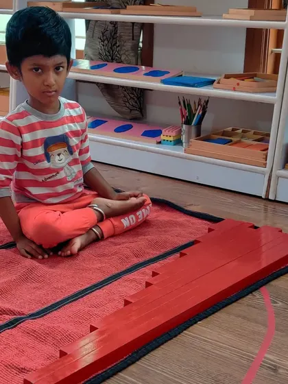 A child immediately engages with the long rods on his first day back. The familiarity and appeal of the Montessori materials draw the children in and help them settle back into the routine.