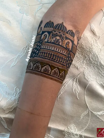 A close-up of a bridal armband featuring a royal palace and peacocks, with beautiful shading that creates depth.