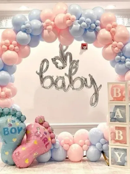 A fun and festive gender reveal balloon arch in classic pink and blue. This setup includes 'Oh Baby' foil balloons, 'BABY' blocks, and giant baby feet foil balloons for a playful announcement.