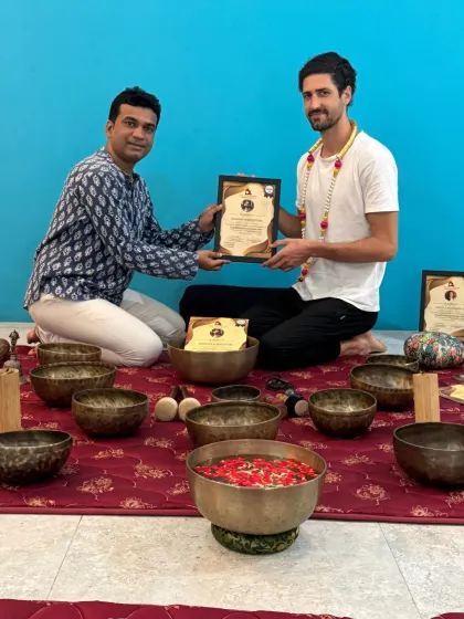 A graduate of our Sound Healing TTC is congratulated as he receives his certificate.