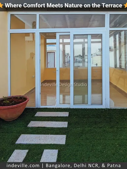 I designed this terrace to be a comfortable extension of the home. It features a glass-enclosed room for all-weather use, with an artificial lawn and stone walkway leading to the open-air section.