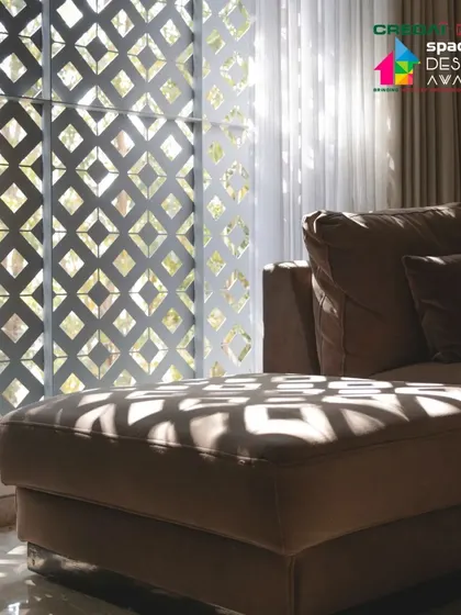 The filtered light creates a soft, diffused glow within the living room, making it a comfortable space to relax at any time of day.