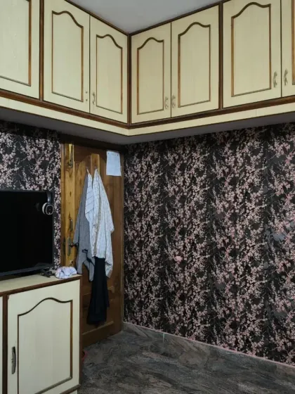 The same dark floral wallpaper used in a bedroom, showing its versatility. I carefully cut around the built-in cabinets for a clean finish.