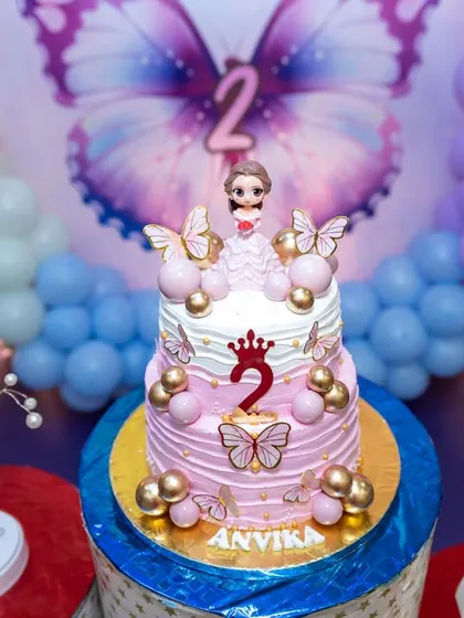 A beautiful two-tiered cake for Anvika's second birthday, featuring a butterfly theme with pink and purple frosting. We capture the details that tie into your party's theme.